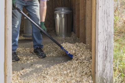 Personne nettoyant son poulailler avec des produits spécialisés.